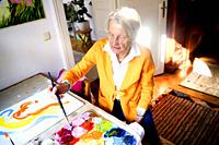 Senior woman painting at home