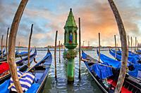 Sunset view of gondolas at St Mark's Square with the island of San Giorgio Maggiore behind , with its church front designed by Andrea Palladio and beg...