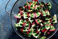 Beet and vegetable pasta in kitchen drainer on artistic background