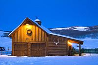 View of ranch barn with holiday wreath at dusk, Crested Butte, Colorado, Rocky Mountains, Winter.