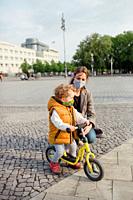 Little boy 2-3 years old with mask and bicycle in Berlin.