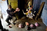 Seraikela Chhau dance mask maker at work ( Jharkhand, India). The idol of the hindu goddess Sarasvati is visible.