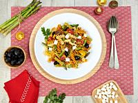 pasta and vegetables dish with pink tablecloth.