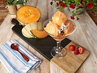 homemade cantaloupe ice cream cup with wood table background.