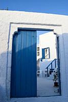 blue door in a typical white house in Santorini, Greece.