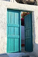 turquoise door in a typical white house in santorini.