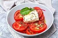 Healthy Homemade Tomato Salad with Mozzarella, Anchovies and Oregano. Healthy food concept.