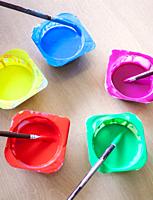 Washable Tempera and rounded paint brushes. Yogurt cups reused as paint containers.