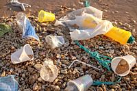 RED SEA, SHARM EL SHEIKH, EGYPT - OCTOBER 18-26, 2020: Plastic debris and face masks on the beach in surf zone. Coronavirus COVID-19 is contributing t...