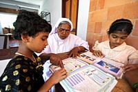 INDIA. Study and reading time, helped by Sister Jane Thennattil (director). Mary Matha Bala Bhavan, a girls' orphanage run by Syro-Malabar Catholic Mi...