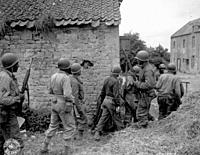 FRANCE Omaha Beachhead -- 10 Jun 1944 -- A platoon of US Army troops surrounds a farm house in a town in France, as they prepare to eliminate a German...
