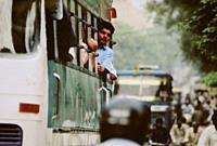 INDIA New Delhi -- Jun 2004 -- A passenger leans out of a bus window in central New Delhi. Crowded streets are the norm in this metropolis and the new...