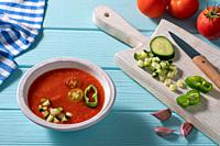Gazpacho Andaluz is an Andalusian tomato cold soup from Spain with cucumber, garlic, pepper on light blue background.