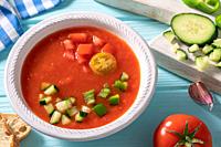 Gazpacho Andaluz is an Andalusian tomato cold soup from Spain with cucumber, garlic, pepper on light blue background.