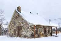 Old 1807 river and fieldstone cottage style house facade in winter, Quebec, Canada. This image is property released. CUPR0325.