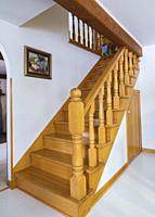 Varnished natural oak wood staircase leading to upper floor inside an old 1807 river and fieldstone cottage style house, Quebec, Canada.