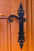 Close-up of black antique metal door handle on wooden bedroom door inside an old 1807 cottage style house, Quebec, Canada.