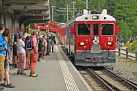 Tourist attraction: Hikers at the train station Morteratsch near Pontresina in the upper Engadin in the Swiss alps.