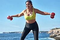 Latin woman, middle-aged, wearing sportswear, training, doing physical exercises, plank, sit-ups, climber's step, burning calories, keeping fit, outdo...