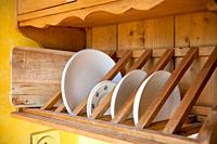 Handmade dishes drying in a wooden rinser