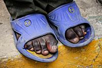 Feet of a young black labourer