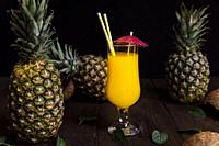 Pineapple juice in a glass with fresh pineapple fruits.