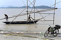 Fishermen lay fishing net in the in the Brahmaputra river, in Guwahati.