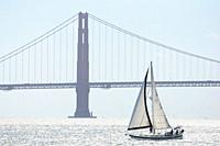 Sailboat crossing the San Francisco Bay, with the Golden Gate Bridge in the background.