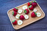 Strawberries with banana on a plate.