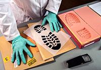 Forensic scientist impatient because he can't find similarity in shoe sole prints in crime lab, concept image.