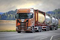 Scania S730 truck of AH-Trans Oy hauls four chemical tank containers on road, ADR codes denoting Sodium. Long transport. Salo, Finland. May 15, 2021.