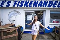 Hirtshals, Denmark July 8, 2021 A young woman posing in front of a local fish store.