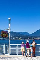 Visiting family looking towards West Vancouver from the cruise ship terminal in downtown Vancouver in British Columbia Canada.