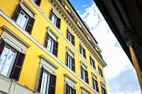 Low angle shot showing details of European classic building with beautiful Italian architectural style window panels located on street of Rome in Ital...
