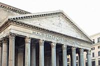 Details of a pediment and large granite Corinthian columns of the Pantheon, ancient Roman temple and Catholic church in Rome, Italy.
