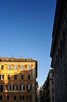 Old building at Piazza di Pietra near Temple of Hadrian in Rome, Italy, with blue sky in background.
