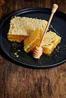 Closeup Honeycomb and honey dipper on wooden table.