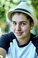 Portrait of young caucasian boy wearing a hat outdoor in a garden. Lifestyle concept.