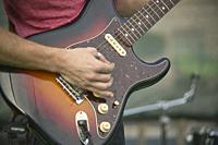 Detail of a Guitarist who plays his electric guitar at a live rock music concert.