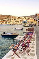 The scenic table and chair lined waterfront of Yialos Town, on the island of Symi, Dodecanese, Greece.