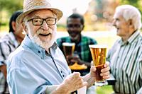 group of senior friends drinking a beer at the park. Lifestyle concepts about seniority and third age.