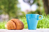 Croissant and tea. Healthy food in the city park.
