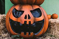 A Halloween decorative dark colored Jack-o-Lantern pumpkin on the street. Halloween and carnival celebration concept.
