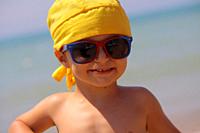 Portrait of a Smiling baby with bandana and sunglasses.