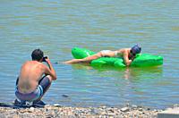 couple at lake, woman floating, New Mexico.