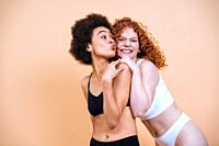 beauty image of two young women with different skin and body posing in studio for a body positive photoshooting. Mixed female models in lingerie on co...