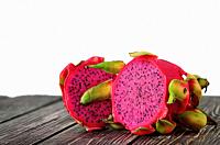 Two halves of dragon fruit on planks isolated on white background.