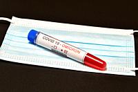 Blood tube for test detection of virus Covid-19 Omicron Variant with positive result on protection mask. Concept of protection from new variant of Omi...
