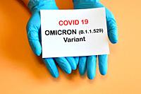 Covid-19 new Omicron variant. The hands of the doctor in blue gloves hold a white paper with the inscription ""Covid-19 variant Omicron"".