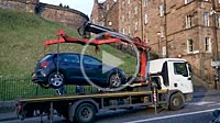 Edinburgh, Scotland: Tow truck in action, lift of wrong poor parked car in Old Town of Edinburgh